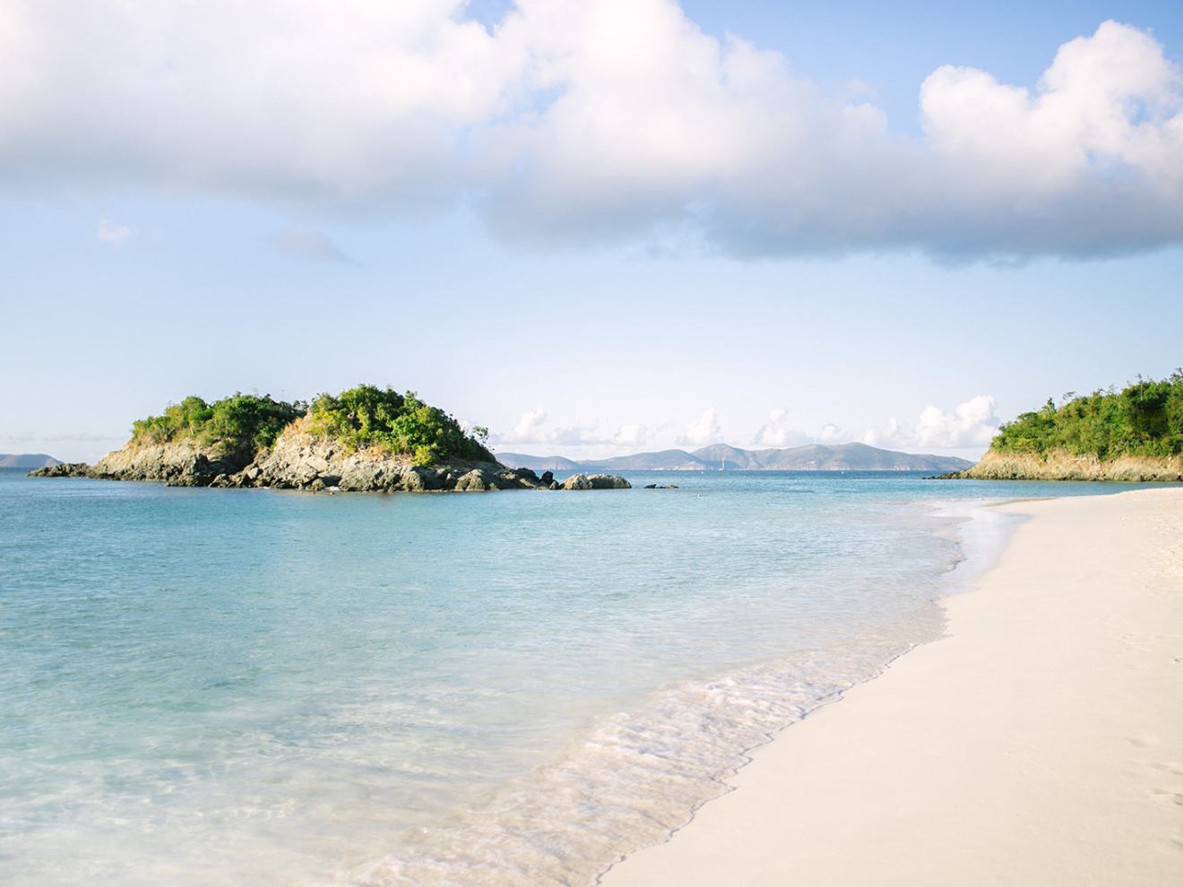 a sandy beach next to a body of water