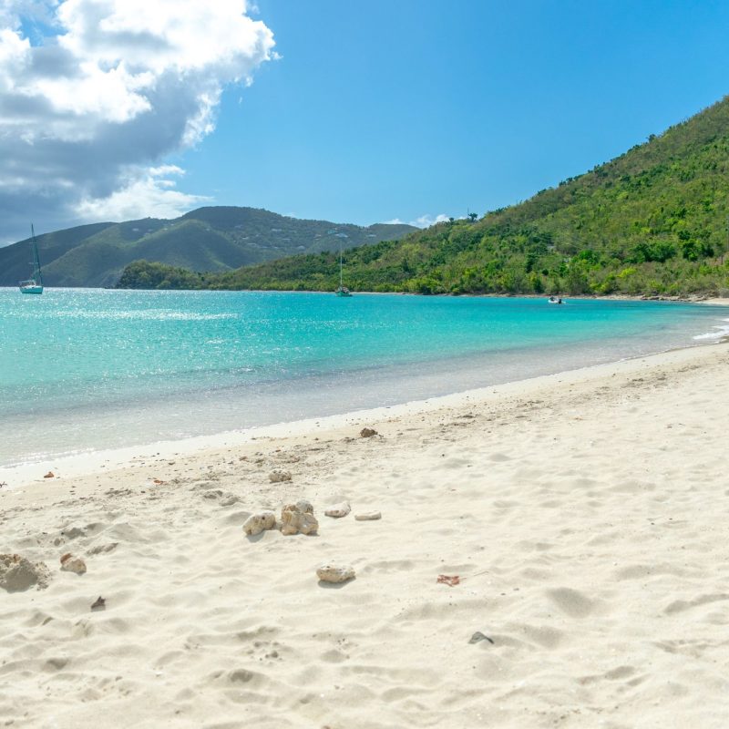 a sandy beach next to a body of water