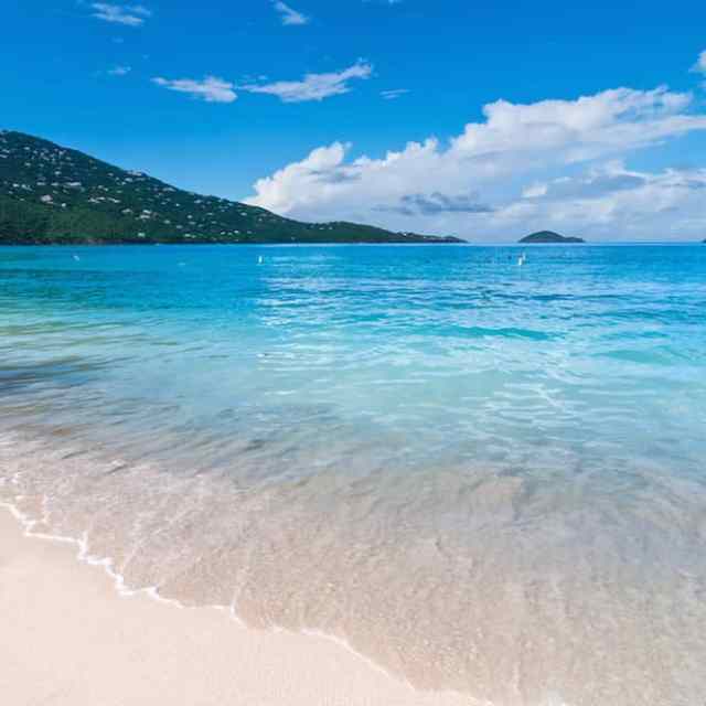 a sandy beach next to a body of water