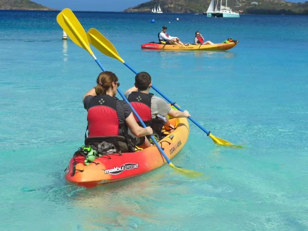 a group of people riding on the back of a boat in the water