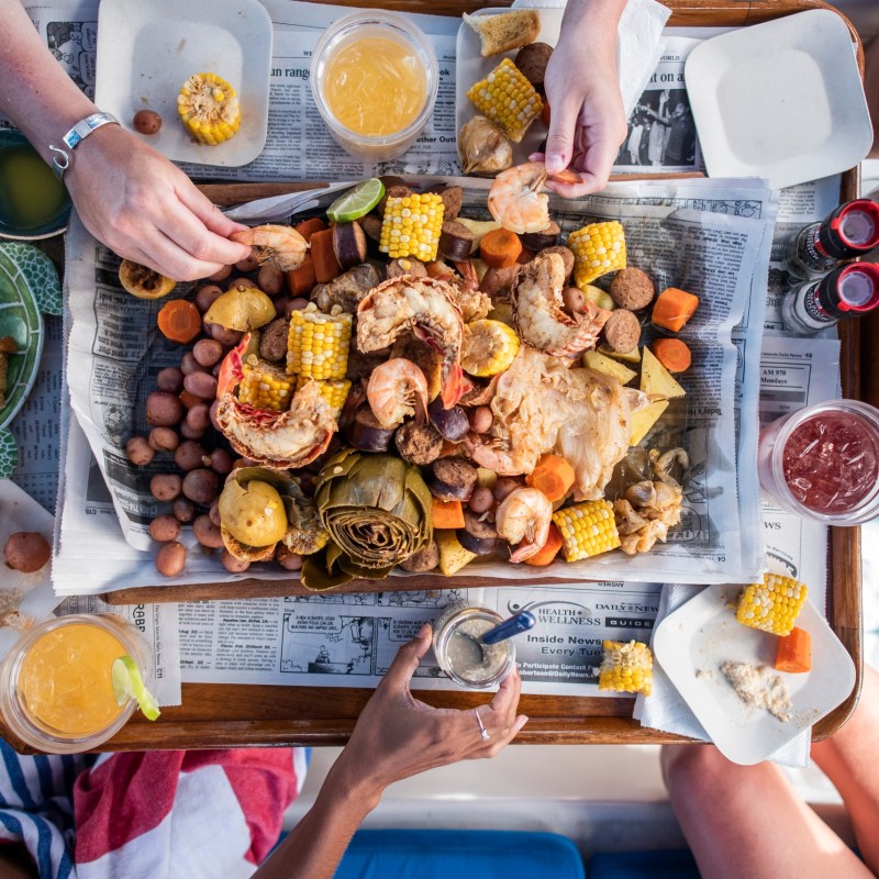 a person holding a bunch of food on a table