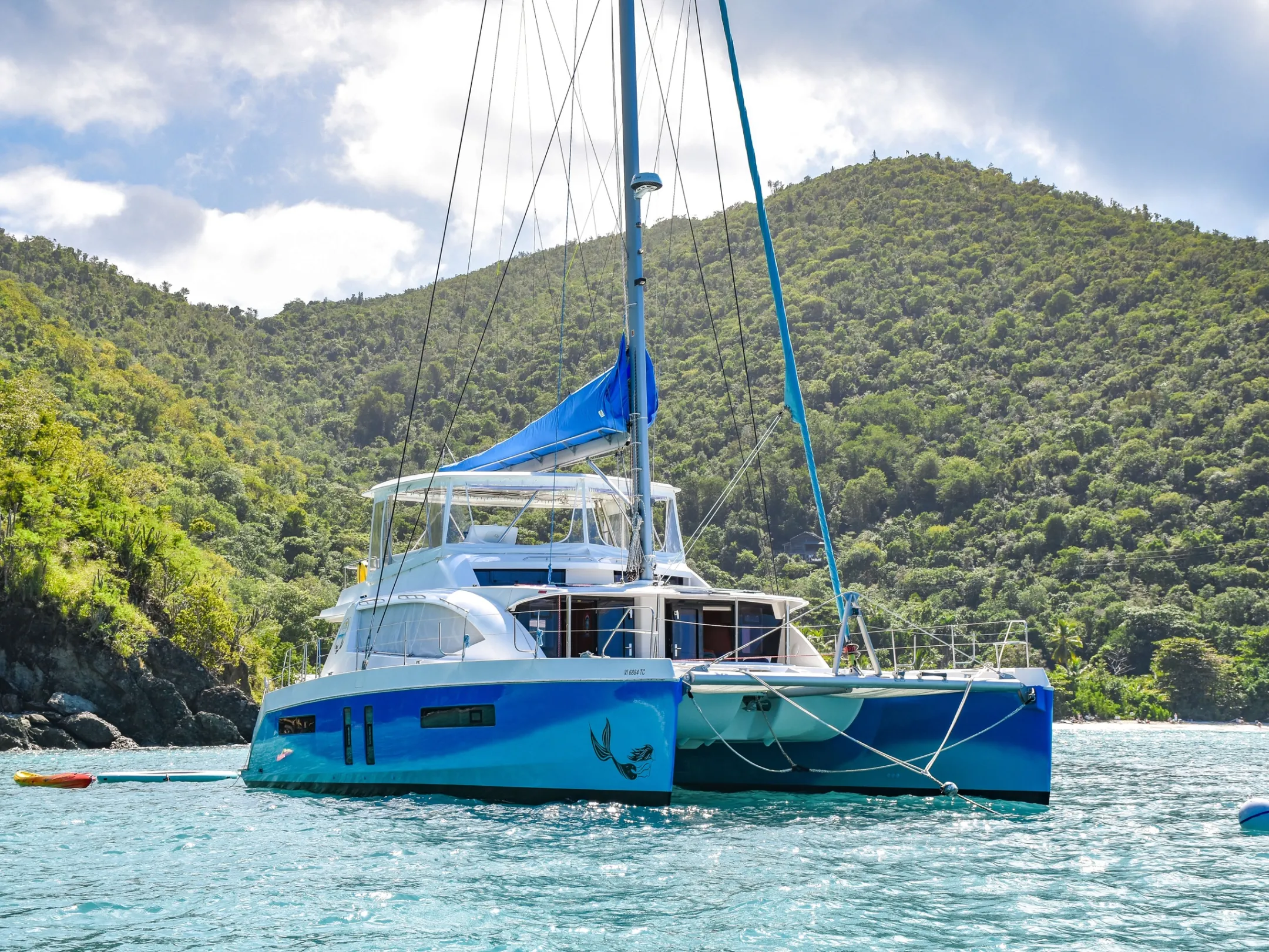 a blue and white boat floating on a body of water