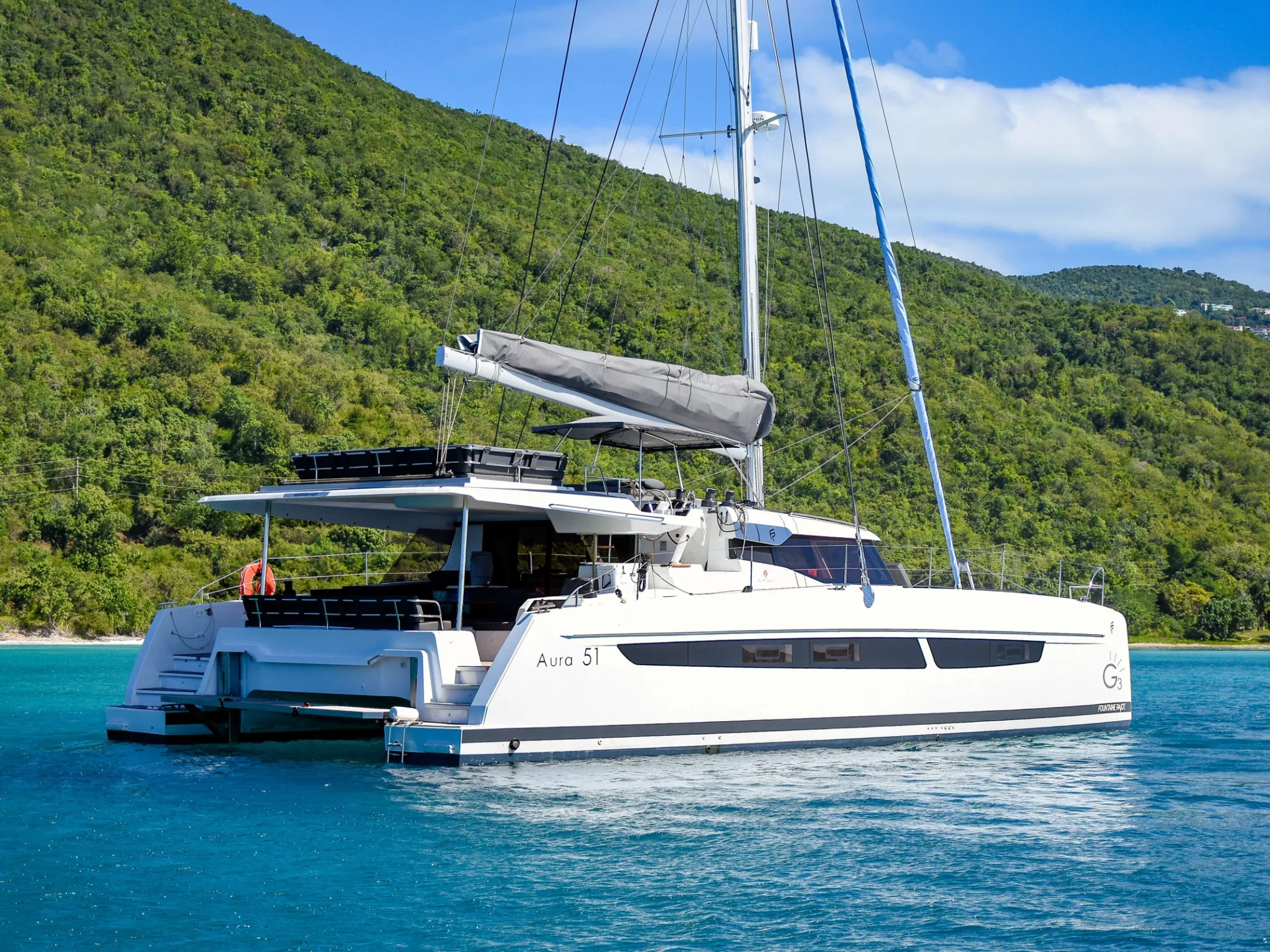 a blue and white boat sitting next to a body of water