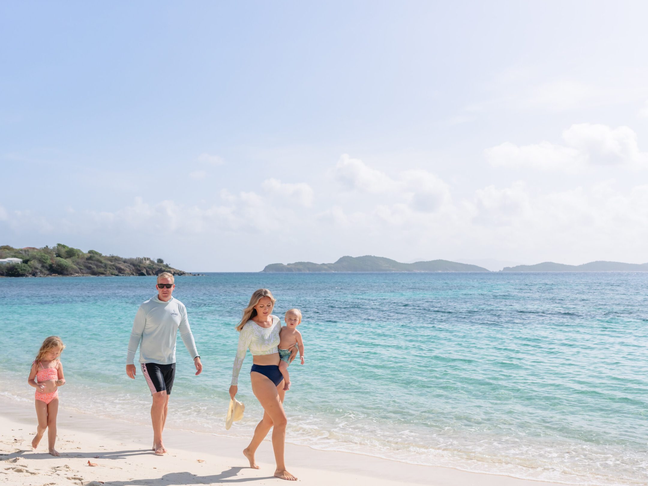 a group of people standing on top of a sandy beach