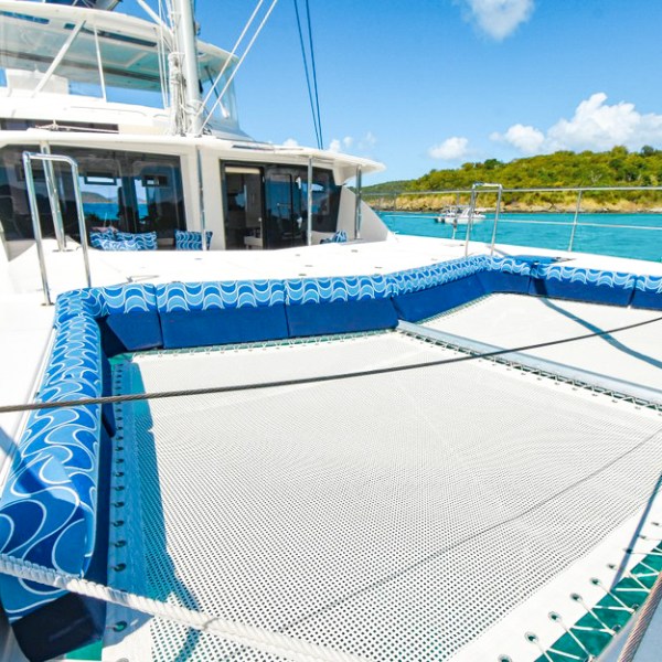 a blue and white boat sitting next to a body of water