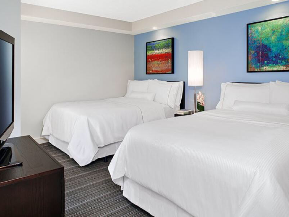 a bedroom with a bed and desk in a hotel room