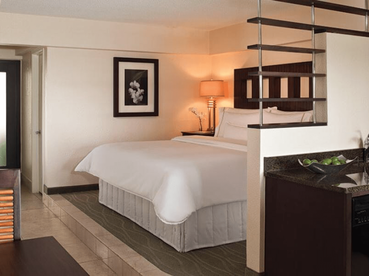 a bedroom with a bed and desk in a hotel room