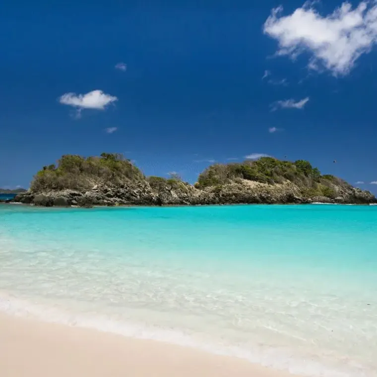 a sandy beach next to a body of water