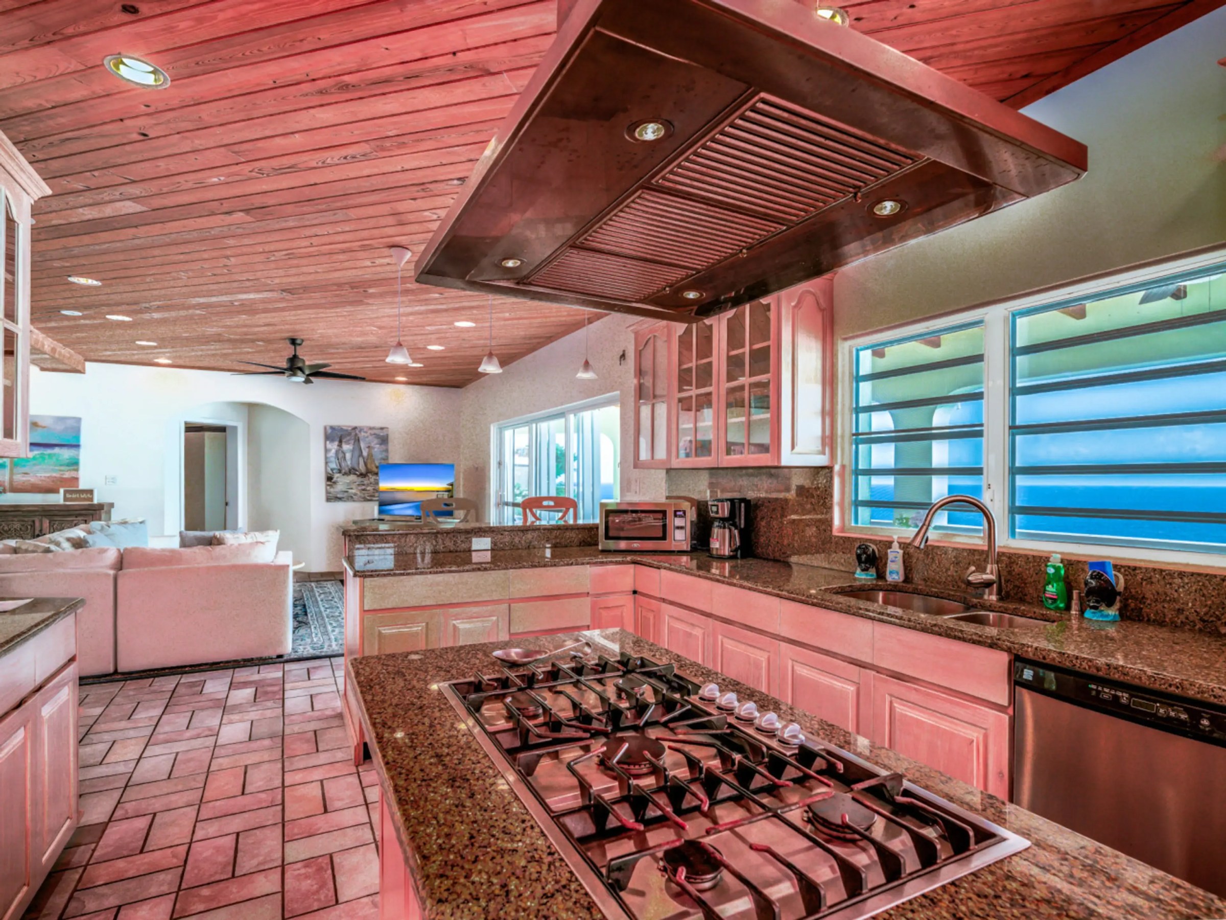 Spacious kitchen with granite countertops, stove, and ocean view window.