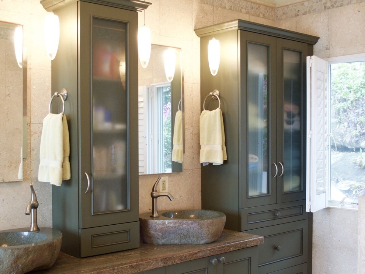Modern bathroom with green cabinets, stone sinks, and soft lighting.