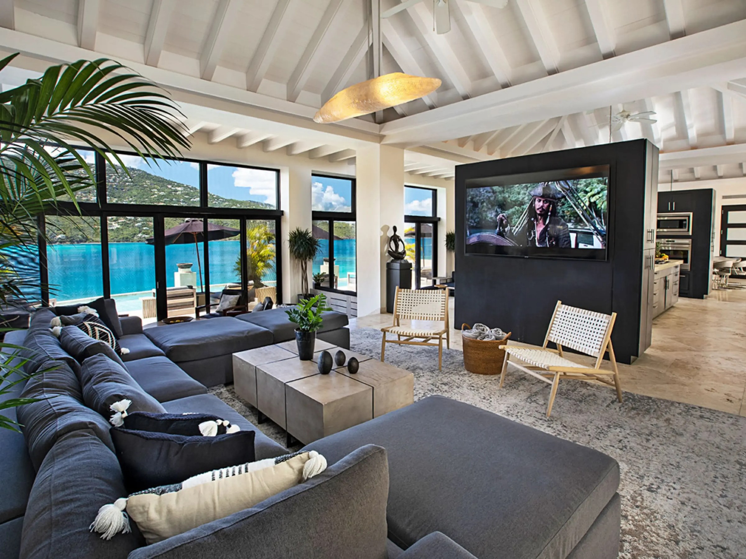 Spacious living room with ocean view, large sofa, TV, and modern decor.