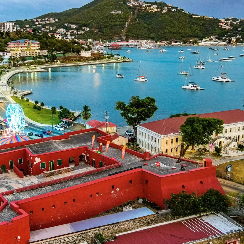 Aerial view of a colorful coastal town with boats on the water.