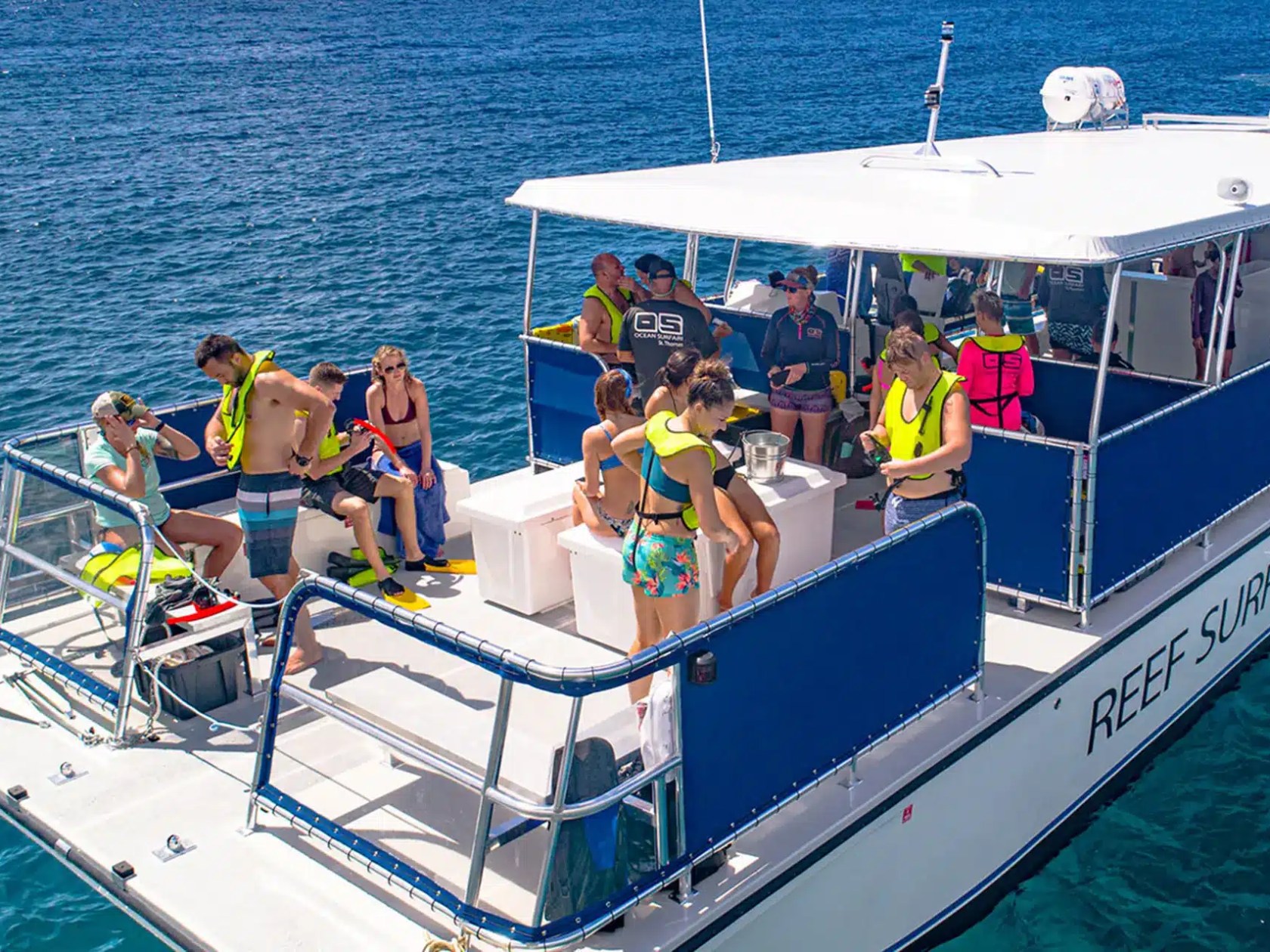 People on a boat wearing life jackets, preparing for a water activity on a sunny day.